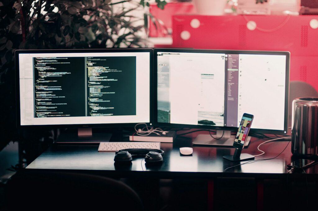 two black computer monitors on black table - What To Learn For Web Development